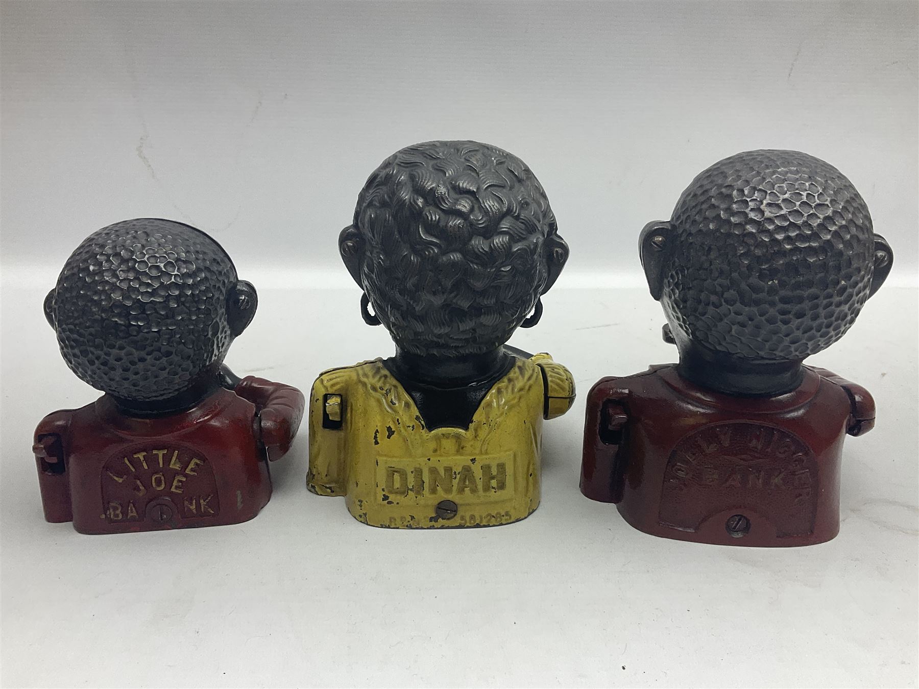 Three early 20th century cast-iron mechanical money banks as a
