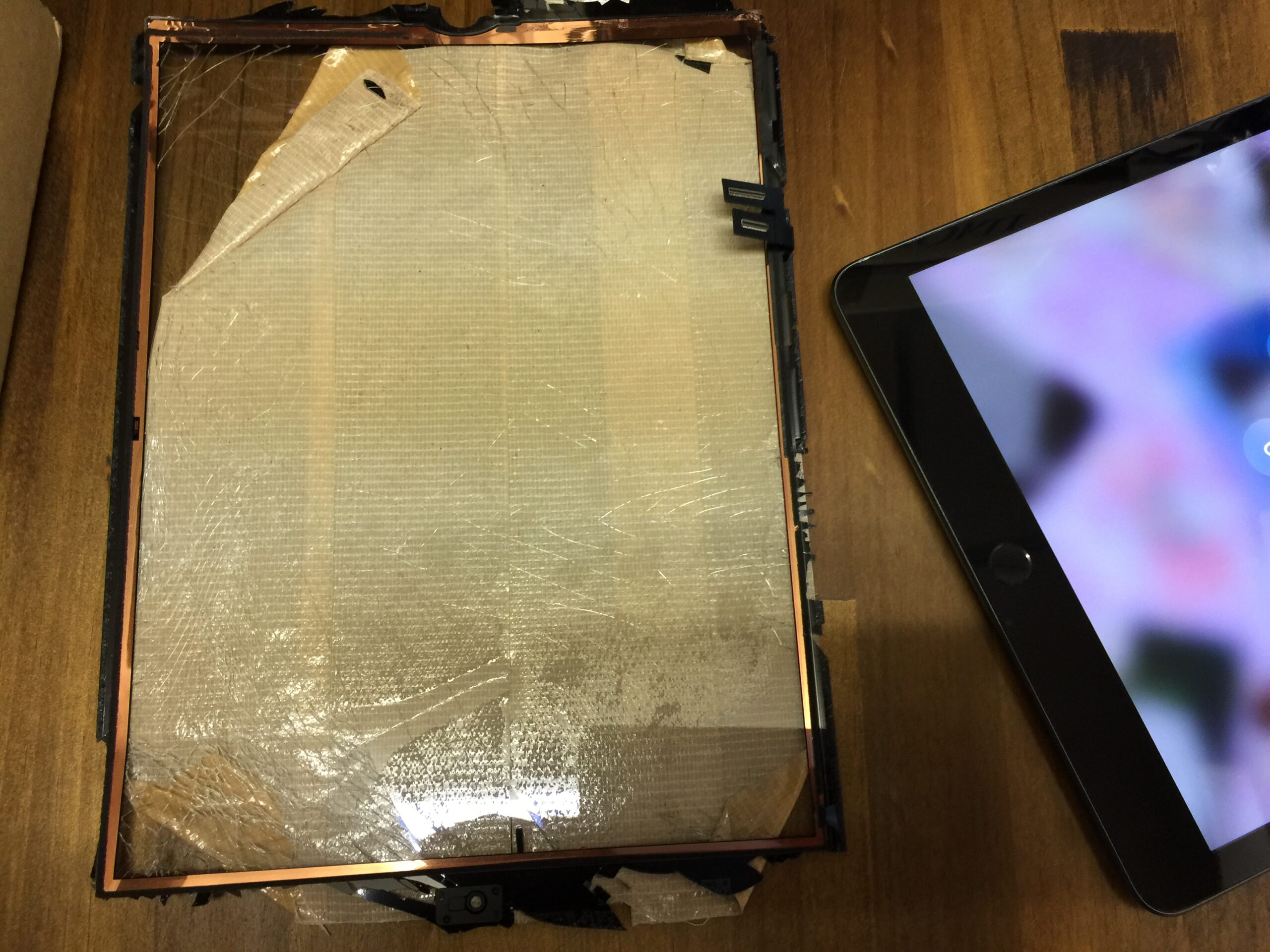 iPad 8 の画面が全体的にひび割れて破片が飛び散っている状態を